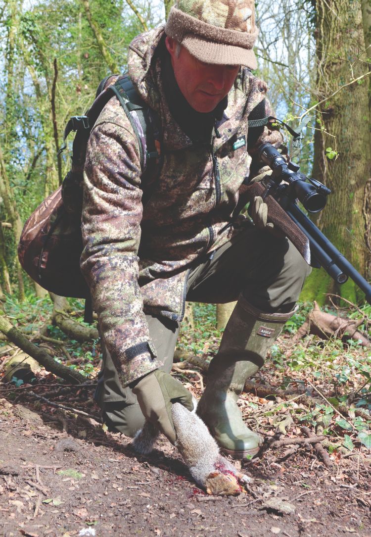 Mat Manning picking up a shot grey squirrel